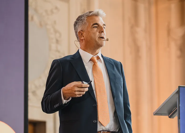 Speaker at Bitfinex Securities Day wearing a cap